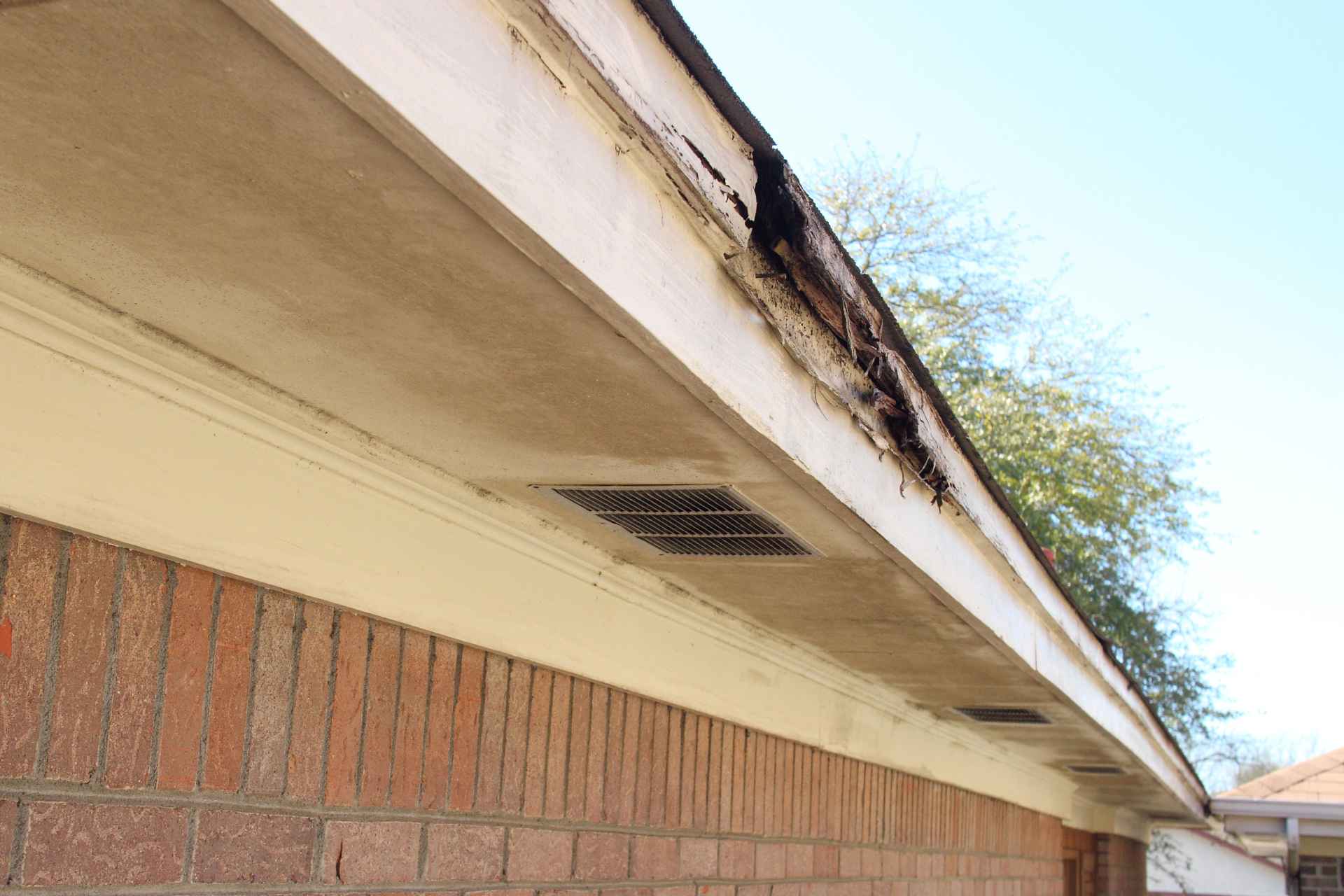 Damaged roof eaves showing severe wood rot and moisture decay.